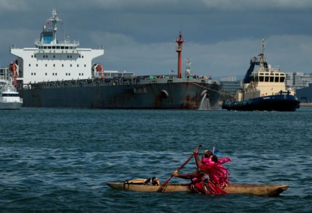 Un activista rema hacia un barco en el puerto de carbón de Newcastle, Australia, para llamar la atención sobre el impacto que tiene el cambio climático en las islas del Pacífico. Crédito: Dean Sewell/Oculi para 350.org