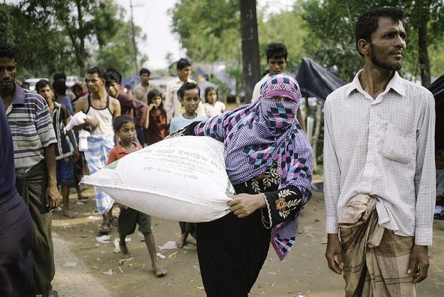 Una refugiada rohinyá carga con suministros humanitarios hasta su refugio improvisado. Crédito: Umer Aiman Khan/IPS.