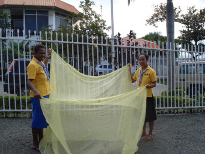 Integrantes de Rotarios Contra la Malaria exhiben uno de los mosquiteros tratados con insecticida que se usan en toda Papúa Nueva Guinea. Crédito: Catherine Wilson/IPS
