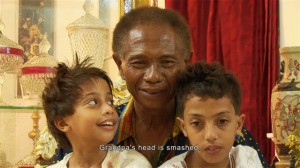 Anwar Congo mira el filme junto a su nieto. Crédito: Cortesía de Joshua Oppenheimer