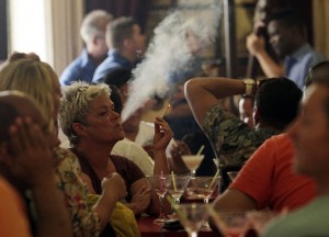 Una clienta fuma un cigarrillo en el bar-restaurante Floridita, en el emblemático barrio de La Habana Vieja. La prohibición de fumar no llega a los bares, restaurantes y centros nocturnos de Cuba. Crédito: Jorge Luis Baños/IPS