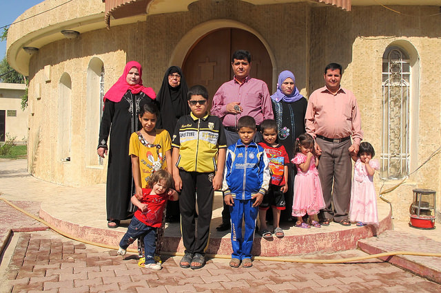 La familia Ismam, de desplazados mandeos que huyen del grupo extremista Estado Islámico, posa en la entrada del Consejo Mandeo de la ciudad iraquí de Kirkuk, donde están acogidos temporalmente. Crédito: Karlos Zurutuza/IPS
