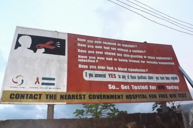 Un cartel en Freetown, Sierra Leona, insta a la población a hacerse la prueba de VIH en los hospitales, una práctica de prevención que disminuyó desde la epidemia de ébola. Crédito: Lansana Fofana/IPS