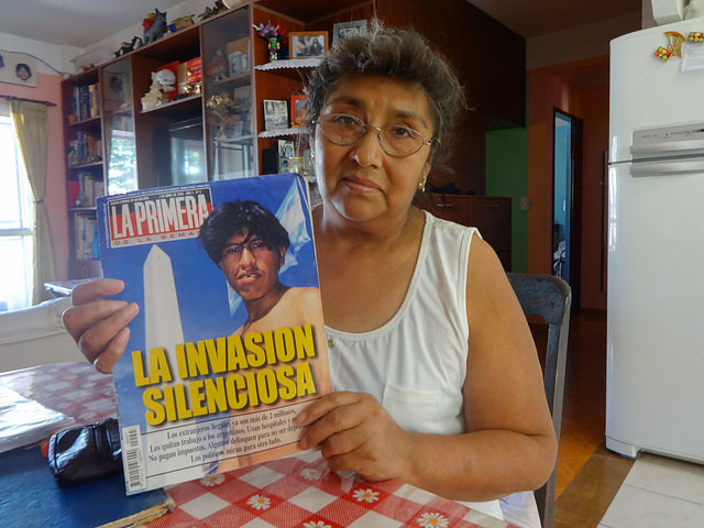 Emiliana Mamani muestra una revista del año 2000, que alertaba de “la invasión silenciosa” de bolivianos en Argentina, donde incluso, aseguró, se manipuló la foto para que el inmigrante apareciese sin un diente. La inmigrante boliviana recuerda aquel episodio como el más duro en sus 30 años en el país de acogida. Crédito: Fabiana Frayssinet/IPS