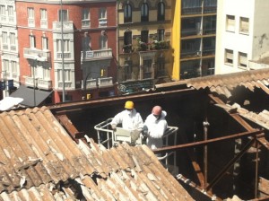 Dos operarios trabajan en la eliminación del amianto en el techo de un edificio que albergó unos cines en el centro de la sureña ciudad española de Málaga, en mayo de 2014. Crédito: Cortesía de la Plataforma Málaga Amianto Cero