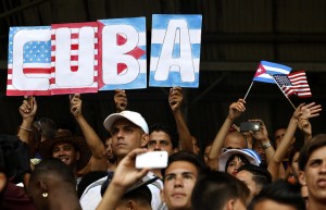 Aficionados con un cartel con las banderas de Cuba y Estados Unidos, durante un partido amistoso de fútbol en La Habana, entre un equipo del país anfitrión y el club Cosmos de Nueva York, el 2 de junio . Este ha sido el primer encuentro deportivo entre equipos de los dos países, tras el inicio del deshielo bilateral, en diciembre. Crédito: Jorge Luis Baños /IPS