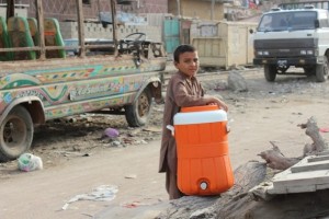 Un niño de un asentamiento informal en Karachi carga con un recipiente para recoger agua en los grifos de viviendas particulares, que los habitantes más pudientes ponen a disposición de los pobres como un acto de caridad. Crédito: Zofeen T. Ebrahim/IPS