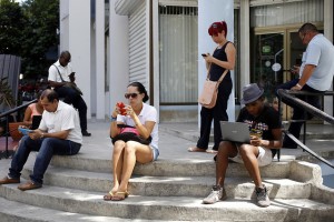 Un grupo de personas en el exterior de la biblioteca médica ubicada en una céntrica calle de El Vedado, en La Habana, donde se puede acceder a Internet por una red inalámbrica. Esta es una de las 35 redes de este tipo instaladas por la estatal Empresa de Telecomunicaciones en el país. Crédito: Jorge Luis Baños/IPS