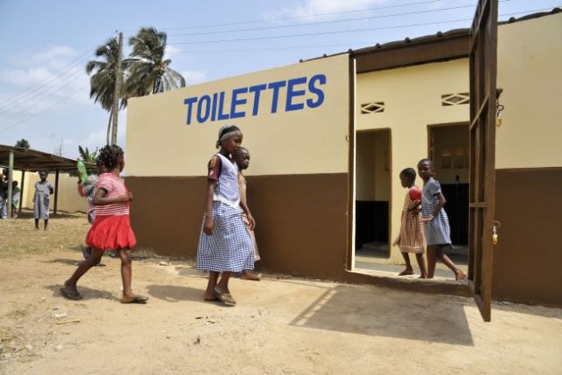 Niñas y niños investigan los nuevos baños mejorados en su comunidad, uno de los "proyectos de rápido impacto" de la Operación de las Naciones Unidas en Costa de Marfil (Onuci), que apoyó la recuperación de escuelas y excusados en Abiyán. Crédito: UN Photo/Patricia Esteve.