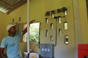 Edgardo Padilla, quien administra el uso de la pequeña central hidroeléctrica, explica cómo opera el proceso y las reglas que han establecido para hacer un uso racional del consumo y distribución de la electricidad en Plan Grande, una comunidad de pescadores de la costa atlántica de Honduras. Crédito: Thelma Mejía/IPS