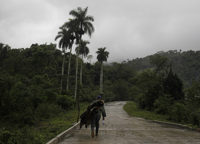 Un hombre transita por un camino cuesta arriba en el municipio montañoso de Victorino, en la provincia de Granma, en Cuba, en un día lluvioso. Crédito: Jorge Luis Baños/IPS
