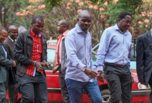 Periodistas del semanario Sunday Mail son trasladados al tribunal en Zimbabwe. La imagen muestra, de izquierda a derecha, a Tinashe Farawo, Brian Chitemba y Mabasa Sasa. Crédito: Jeffrey Moyo / IPS.