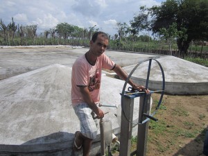 Abel Manto en la terraza con cisternas cerradas para recoger el agua de lluvia e irrigar sus huertos, en el estado de Bahia, en Brasil. El verde de la finca de este campesino e inventor contrasta con la aridez de la región, mientras que el sistema de cerramiento de sus cisternas impide que los mosquitos infecciosos aniden en el líquido. Crédito: Mario Osava/IPS