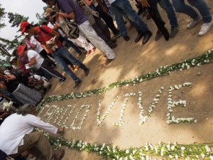"Camilo Vive", dibujaron con claveles blancos sobre la arena de la carretera sin pavimentar que conduce del puerto fluvial de Barrancabermeja, en el centro de Colombia, al municipio El Carmen de Chucurí, en el departamento de Santander. Unos 700 peregrinos participaron en el homenaje a Camilo Torres, por cumplirse el 15 de febrero medio siglo de su muerte en combate. Crédito: Constanza Vieira/IPS
