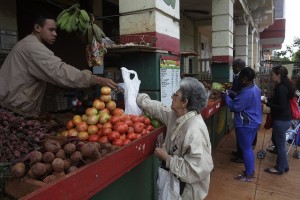 Una mujer paga la compra de productos agrícolas en un mercado administrado por trabajadores por cuenta propia, donde se venden frutas y verduras de la cooperativa Nicomedes Corvo, en el barrio de El Vedado de La Habana, en Cuba. Crédito: Jorge Luis Baños/IPS