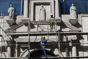 Dos trabajadores realizan labores de mantenimiento en la fachada del Colegio Universitario San Gerónimo, en La Habana Vieja, en vísperas de la llegada del presidente de Estados Unidos, Barack Obama, a Cuba. Calles y edificios reciben un lavado de cara, mientras nadie en la capital permanece indiferente ante la histórica visita. Crédito: Jorge Luis Baños/IPS