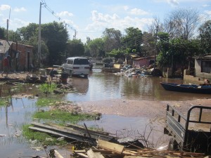 Una de las muchas calles de Bañado Norte que aún permanecían inundadas e intransitables en marzo de 2016, semanas después de la crecida del río en Asunción, en la capital de Paraguay, que obligó a desalojar sus pobres viviendas a cerca de 14.000 personas. Crédito: Mario Osava/IPS