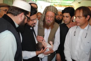 El conocido religioso Maulana Samiul Haq administra la vacuna contra la poliomielitis a un bebé en Pakistán. Crédito: Ashfaq Yusufzai/IPS.