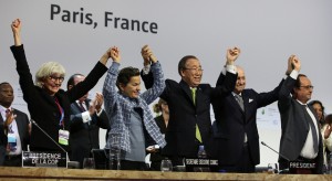 En la tarima del plenario de la COP21, el secretario general de la Organización de las Naciones Unidas, Ban Ki-moon, en el centro, junto con otros dignatarios celebran el 12 de diciembre el alcance del histórico Acuerdo de París sobre el cambio climático, que ahora se firma en Nueva York. Crédito: Naciones Unidas