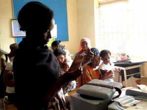 Mujeres esperan para vacunar a sus hijos en el Centro de Salud Kisugu en Kampala, Uganda. La enfermera en primer plano es Betty Makakeeto. Crédito: Amy Fallon/IPS