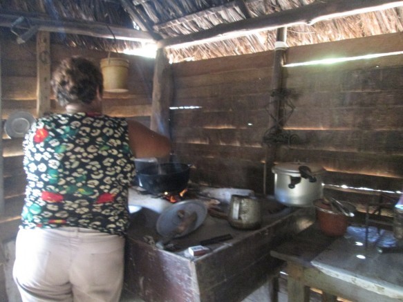 Una residente en Arroyo Colorado prepara la comida en su cocina de leña. La llegada de la electricidad a pequeños asentamientos de zonas montañosas de Cuba neutralizaría el éxodo de los jóvenes de esas zonas hacia las ciudades. Crédito: IPS Cuba