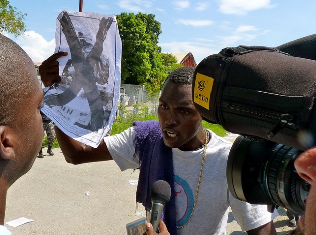Un manifestante sostiene un cartel contra la ONU durante una protesta frente a una base de la organización en Puerto Príncipe, Haití. Crédito: Ansel Herz / IPS
