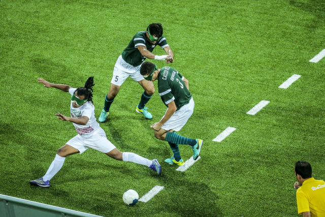 Dos futbolistas brasileños invidentes disputan el balón a un iraní durante un partido de la modalidad de cinco jugadores, durante los Juegos Paralímpicos de Río 2016. Brasil ha sido medalla de oro durante los últimos cuatro Juegos. Crédito: Danilo Borges/Brasil2016