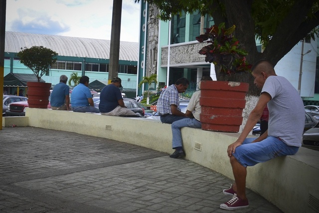 Algunos hombres pasan el tiempo sentados en un muro, frente a la Sección 30 del sindicato petrolero, en la oriental ciudad de Poza Rica, en México. Crédito: Edgar Escamilla/Pie de Página