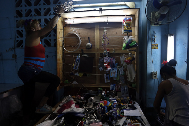 Dos mujeres preparan los productos para la venta en un pequeño puesto dentro de un edificio en La Habana. El envío de dinero o productos por familiares desde el exterior ha hecho prosperar estos negocios privados en Cuba. Crédito: Jorge Luis Baños/IPS