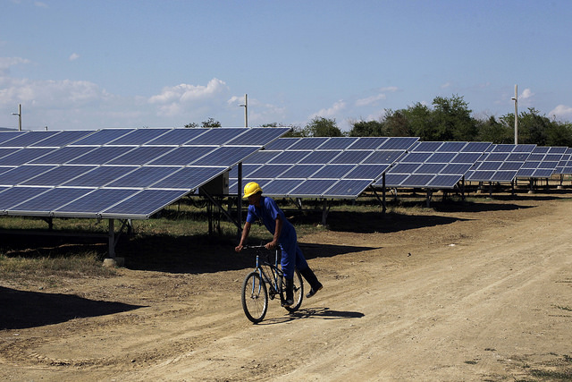 Un operario supervisa en bicicleta las 5,5 hectáreas cubiertas por los conversores de electricidad en el Parque Solar Fotovoltaico Santa Teresa, en la periferia sur de Guantánamo, en el oriente de Cuba. Se aspira a que la instalación cuente con 34 hectáreas de paneles. Crédito: Jorge Luis Baños/IPS