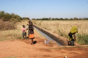 Niñas y niños recolectan agua de un canal en el sistema de irrigación de Magwe en el sur de Matabeleland, Zimbabwe. Crédito: Busani Bafana/IPS.