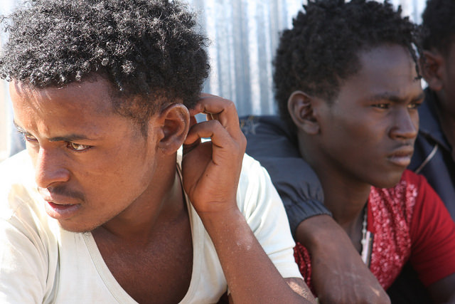 Jóvenes y adolescentes eritreos de entre 16 y 20 años esperan en el punto de ingreso de Badme a que los trasladen al centro de registro. Crédito: James Jeffrey/IPS.