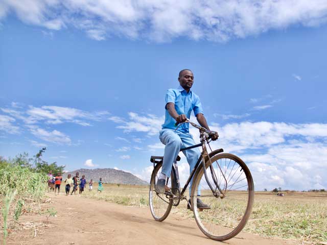 El asistente de Vigilancia de la Salud, Noah Chipeta, se traslada en bicicleta desde de la comunidad de Chanthunthu al centro de salud más cercano, a 17 kilómetros, para reabestecer el botiquín de medicamentos de la clínica rural del distrito de Kasungu, en Malawi. Crédito: UNICEF.