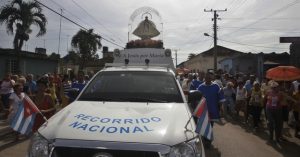 La imagen de la Virgen de la Caridad del Cobre, patrona de los católicos en Cuba, pasa en medio del fervor popular por un pequeño suburbio rural de La Habana, durante un recorrido por varias localidades del país. Las nuevas iglesias protestantes restan cada vez más fieles a la tradicional Iglesia Católica. Crédito: Jorge Luis Baños/IPS