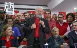 “Elección sin Lula es fraude”, reza un cartel detrás de Luiz Inácio Lula da Silva, durante su comparecencia ante los medios tras ser condenado en primera instancia a nueve años y medio de prisión. Si la sentencia es ratificada por un tribunal de apelación, antes de las elecciones de octubre de 2018, se cerrará su posibilidad de volver a la presidencia. Crédito: Ricardo Stuckert/Fotos Públicas