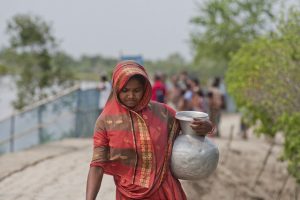 Una mujer carga con un recipiente lleno de agua para beber en el área costera de Bangladesh. Crédito: Rafiqul Islam/IPS.