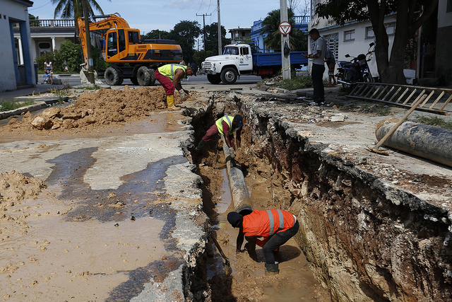 Trabajadores de la empresa estatal Aguas de La Habana ejecutan la rehabilitación de una red para el drenaje de las aguas residuales, en una calle del municipio Marianao, en la capital de Cuba. Crédito: Jorge Luis Baños/IPS