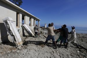 Trabajadores recuperan los muros derribados de una vivienda en construcción en las inmediaciones de la playa de Guanabo, que resultó severamente afectada por las penetraciones del mar al paso del huracán Irma, en el municipio de Habana del Este de la capital de Cuba. Crédito: Jorge Luis Baños/IPS