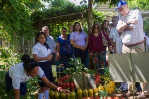 El representante regional para América Latina y el Caribe de la FAO, Julio Berdegué (derecha), y otros visitantes escuchan las explicaciones de dos alumnas de la escuela de Pepenance, una aldea de El Salvador, sobre la producción de vegetales en el huerto del centro. Crédito: Edgardo Ayala/IPS