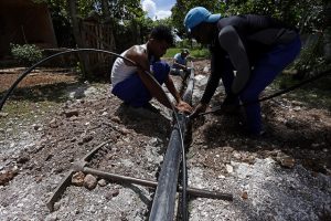 Operarios instalan tubos de la red hidráulica de agua potable en un área de viviendas del municipio de La Lisa, uno de los que conforman La Habana, en Cuba. Crédito: Jorge Luis Baños/IPS