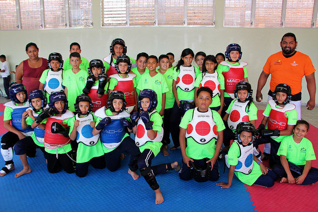 Parte del grupo de niños que practican taekwondo, junto a un instructor y una de las madres. Su alegría prueba que los cambios en los empinados barrios marginales de Tegucigalpa son posibles, si se invierte en dignificarlos. Crédito: Thelma Mejía/IPS