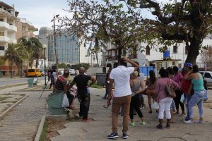 Contrario a lo habitual, unas pocas personas aguardan en una plaza cercana a la sede de la Embajada de Estados Unidos en La Habana, al fondo a la izquierda, para intentar realizar trámites, después que la expedición de visas quedó suspendida el 29 de septiembre. Crédito: Jorge Luis Baños/IPS
