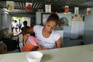 Una empleada de la tienda de jugos El Framboyán sirve uno de fruta bomba. Sus jugos se elaboran con frutas cosechadas en Jibacoa, la cercana finca ubicada en Boyeros, en la periferia sur de La Habana, en Cuba. Crédito: Jorge Luis Baños/IPS