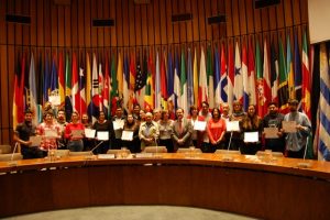 Varios de los periodistas participantes posan en el Salón Celso Furtado de la Cepal, donde se desarrolló el seminario taller de dos días, con los certificados recién recibidos, en el acto de cierre del seminario-taller realizado en Santiago. Crédito: IPS