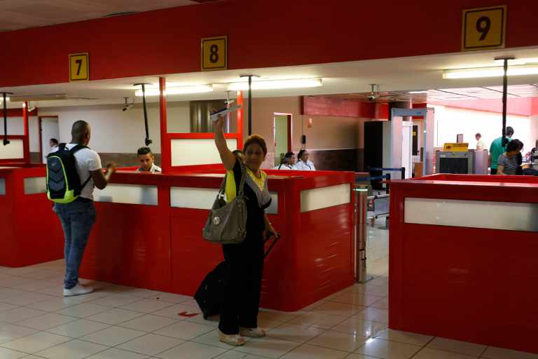 Una mujer hace un gesto de despedida momentos previos de abordar un vuelo en la terminal 3 del Aeropuerto Internacional José Martí, en La Habana, Cuba, en junio de 2017. Crédito: Jorge Luis Baños/IPS.