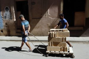 Dos jóvenes transportan bloques de construcción artesanal destinados a la ampliación de una vivienda en La Habana Vieja, en Cuba. Crédito: Jorge Luis Baños/IPS