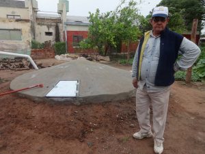 Un campesino junto a una cisterna comunitaria para recoger agua de lluvia, con la cual un grupo de familias mitigan los efectos para su producción agrícola y sus necesidades domésticas de las recurrentes sequías que asolan los parajes rurales de la norteña provincia argentina de Chaco, parte de una de las regiones latinoamericanas con mayor erosión de sus suelos. Soluciones como esta mejoran la vida de pobladores en las tierras degradadas de la región. Crédito: Fabiana Frayssinet/IPS