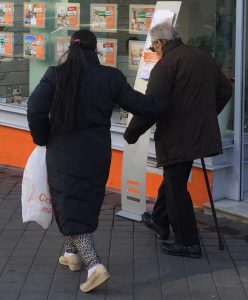 Una persona mayor camina con la ayuda de su cuidadora por la calle Potosi, desde la calle Colombia a la avenida La Habana en Madrid, España. Crédito: Baher Kamal/IPS.