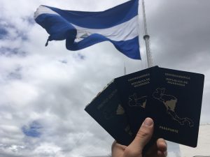 Bajo una bandera de Nicaragua unos pasaportes de ese país, en cuya portada resalta la silueta del mapa centroamericano con la parte nicaragüense destacada. Su frontera sur, limítrofe con Costa Rica, se ha convertido en un “muro de contención” de los migrantes que transitan desde América del Sur hacia el norte, para llegar a Estados Unidos. Crédito: José Adán Silva/IPS