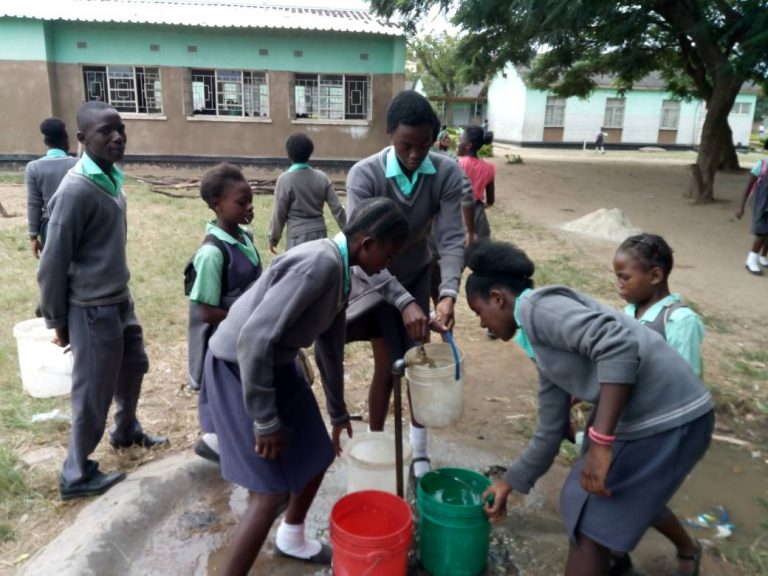 Estudiantes de la escuela primaria Matero East, en Zambia, recolectando agua. Crédito: Munich Advisors Group